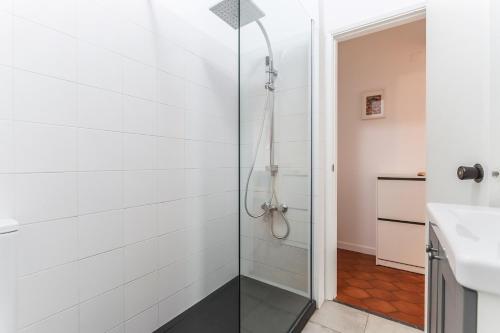 a glass shower in a bathroom with a sink at Vita Portucale ! Surf Concept Costa Caparica in Costa da Caparica
