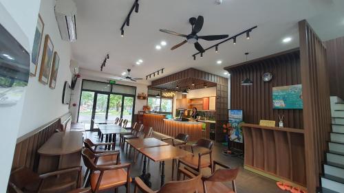 a restaurant with tables and chairs and a ceiling fan at Xan hotel Phu Quoc in Phu Quoc