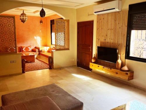 a living room with a television and a living room with a couch at Villa Dar Bella in Aït Ali