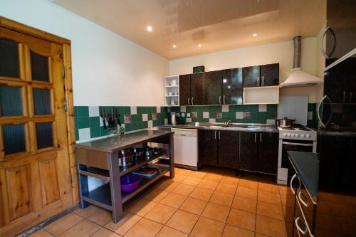 a kitchen with green and white tiled walls at Alaušo Salos - Malinauskų kaimo turizmo sodyba in Sudeikiai