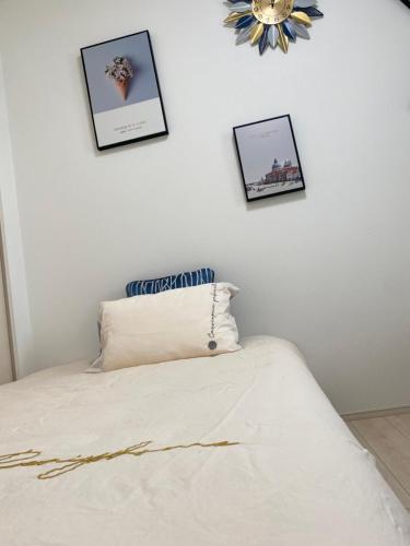 a bedroom with a bed with three pictures on the wall at Arts Candy Sapporo-Villa Nakajima in Sapporo