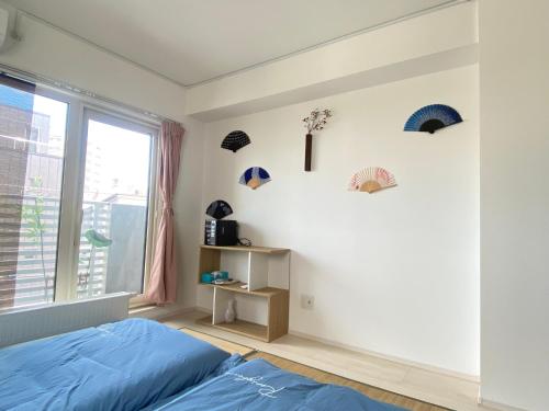 a bedroom with a blue bed and a window at Arts Candy Sapporo-Villa Nakajima in Sapporo