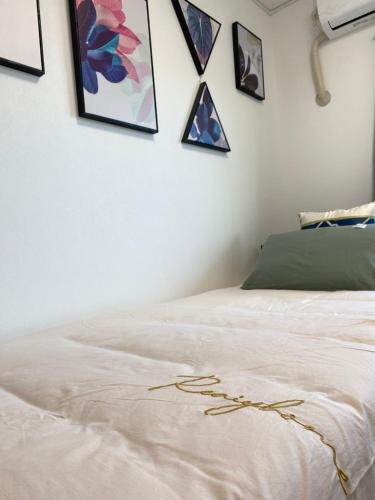 a white bed in a room with pictures on the wall at Arts Candy Sapporo-Villa Nakajima in Sapporo