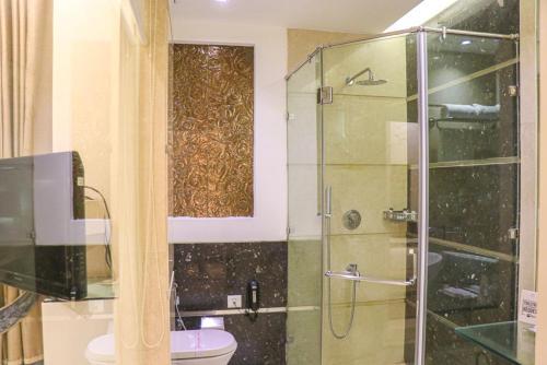 a bathroom with a glass shower and a toilet at Hotel Eternity in New Delhi