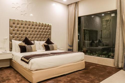 a bedroom with a large bed and a large window at Hotel Eternity in New Delhi