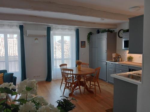 une cuisine et une salle à manger avec une table et des chaises dans l'établissement La Lavandière, à Puimoisson