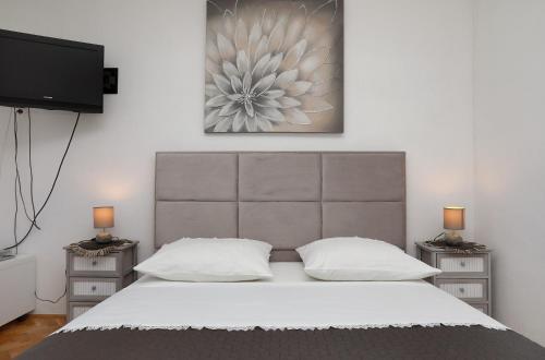 1 dormitorio con 1 cama grande y 2 mesitas de noche en Apartments ITD, en Trogir