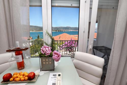 una mesa con frutas y flores en el balcón en Apartments ITD, en Trogir