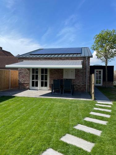 a house with solar panels on top of a yard at Vakantiewoning De Krab in Sint Annaland