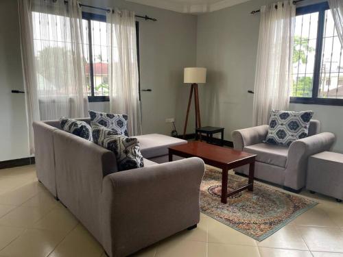 a living room with two couches and a coffee table at Cheerful studio apartment in Dar es Salaam