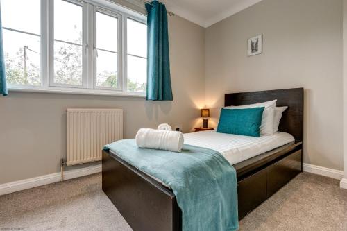 a bedroom with a bed with a blue blanket on it at The Didcot White House in Didcot