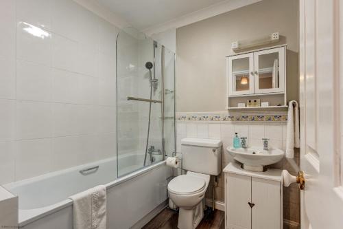 a bathroom with a toilet and a sink and a shower at The Didcot White House in Didcot