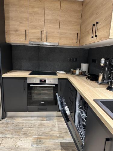 a kitchen with wooden cabinets and a stove top oven at Magic View Luxury Villa 4u - Spiro Spero in Kineta