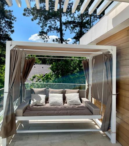 a couch in a pergola on a patio at Gold Wave Apartments in Siófok