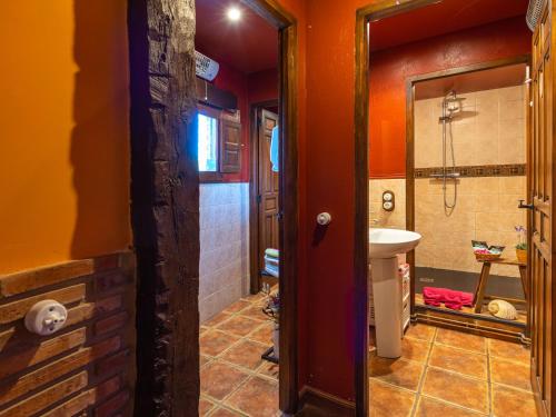 uma casa de banho com paredes cor-de-laranja, um lavatório e um espelho. em Loft & Garden em Ventosa