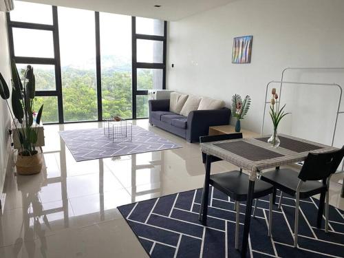 a living room with a couch and a table and chairs at Recov Guest House, The Square, One City, USJ25 in Subang Jaya