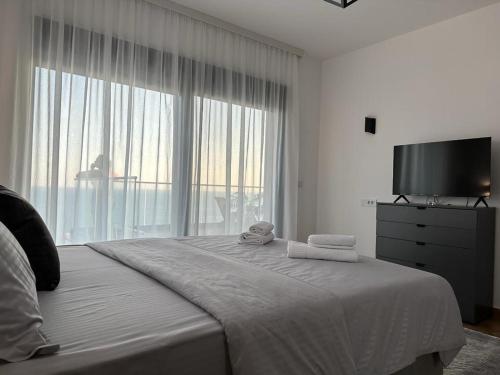 a bedroom with a large bed with towels on it at Nejra Apartment in Ulcinj