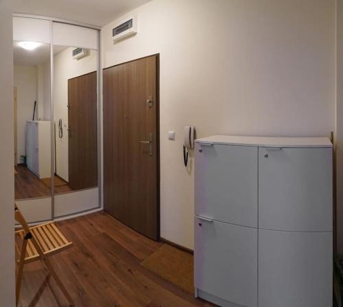 Camera con frigorifero bianco e pavimento in legno. di Mieszkanie wakacyjne, wypoczynkowe a Polanica-Zdrój