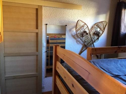 - une chambre avec un lit et un ventilateur mural dans l'établissement T2 aux 2 Alpes - pied des pistes - centre station, à Les Deux Alpes
