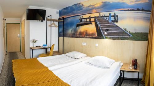 a bedroom with a large bed with a painting on the wall at Centrum Konferencyjno Rekreacyjne Molo in Smardzewice
