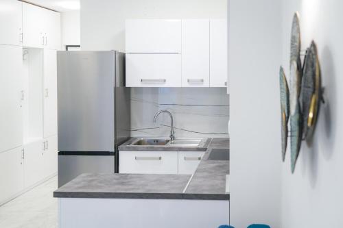 een keuken met witte kasten en een roestvrijstalen koelkast bij Apartment Blue in Makarska