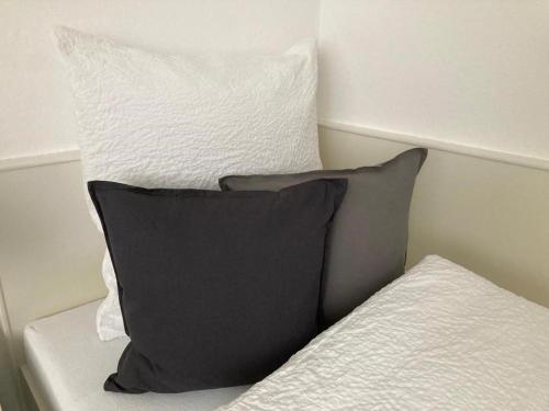 a black pillow sitting on top of a bed at Schönes Zimmer in guter Lage in Aalen/Unterkochen in Unterkochen
