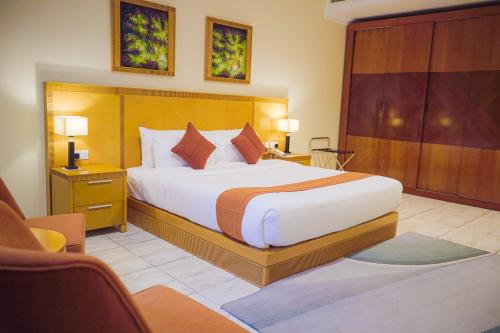 a bedroom with a large bed in a hotel room at City Seasons Hotel & Suites Muscat in Muscat