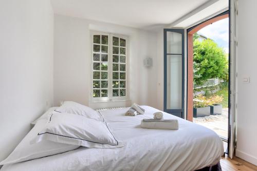 een wit bed in een kamer met een raam bij Le Cottage - Maison avec vue imprenable in Saint-Cast-le-Guildo