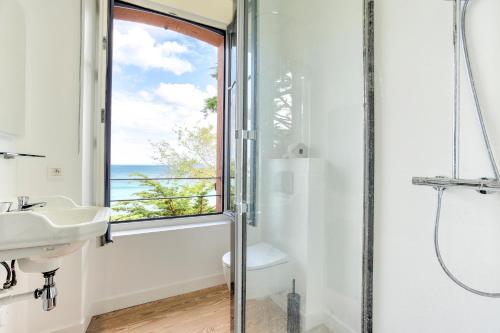 ein Bad mit einer Dusche, einem Waschbecken und einem Fenster in der Unterkunft Le Cottage - Maison avec vue imprenable in Saint-Cast-le-Guildo