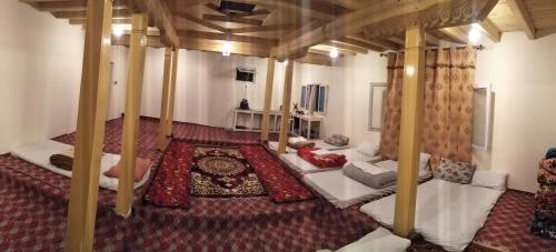 Karakorum Family Guest House Hunza في هنزه: غرفة معيشة مع أرائك بيضاء في غرفة