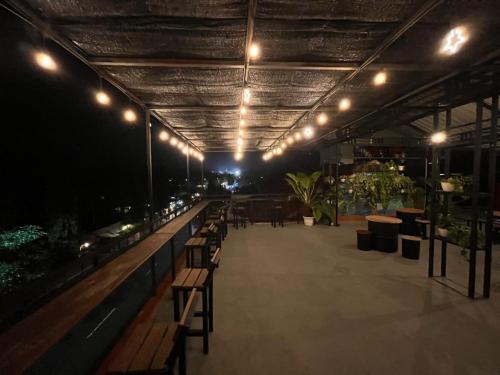um pátio com bancos e luzes à noite em Omahku Homestay em Borobudur