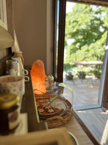 a glass jar of food on a counter next to a window at Agriturismo Podere Orzale Hospitality & Quarter Horses in Usigliano
