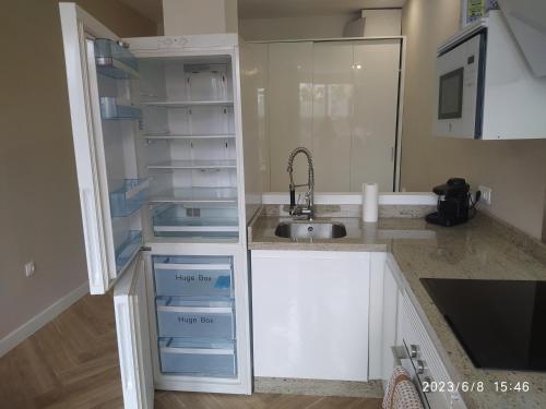 uma cozinha com armários brancos e um lavatório em Estudio al lado de la Playa em Fuengirola
