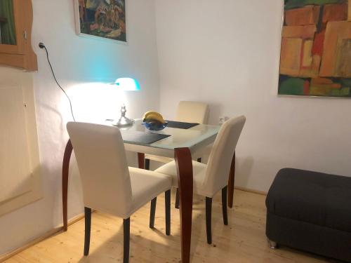 einen Esstisch mit weißen Stühlen und einer Lampe in der Unterkunft Brač, Supetar, ART HOUSE, Dreamy Dalmatian vacation home, 80m from sea in Supetar