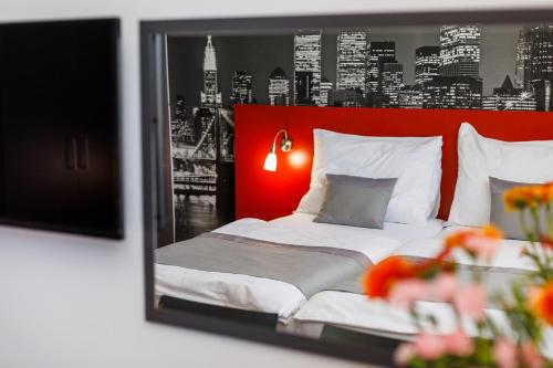 a bedroom with a bed with a red head board at Hotel Vista in Brno