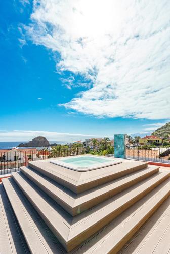 a set of stairs leading up to a swimming pool on a building at Studios by Aqua Natura Hotels in Porto Moniz