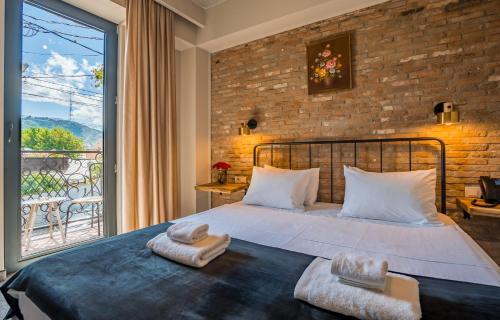 1 dormitorio con cama y ventana grande en Twentyone By Vintage Hotel Collections, en Tiflis