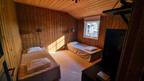 a small room with two beds and a window at Skurdalsvegen 37L in Geilo