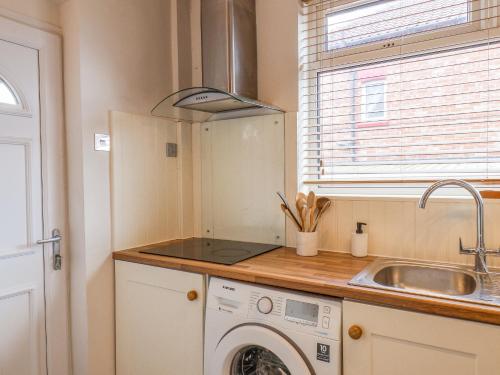 a kitchen with a washing machine and a sink at 12 Westfield Terrace in Saltburn-by-the-Sea