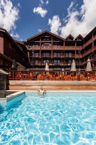 une personne dans la piscine d'un hôtel dans l'établissement Résidences Village Montana by Les Etincelles, à Tignes
