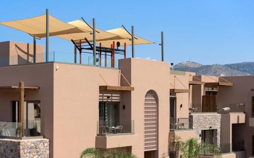 a building with chairs on top of it at Paralos Venus Suites Adults Only in Hersonissos