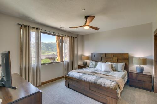Schlafzimmer mit einem Bett, einem TV und einem Fenster in der Unterkunft Powder Mountain Home with Private Hot Tub and Views! in Eden