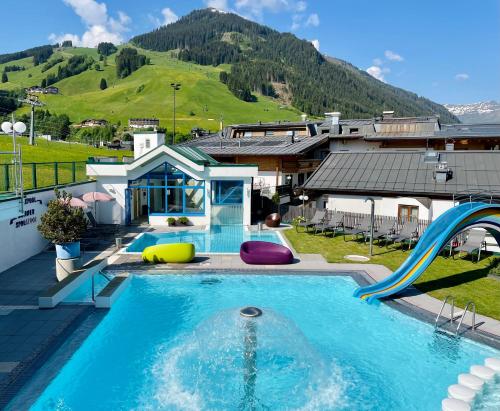 a swimming pool with a slide in a house at Wellness- und Familienhotel Egger in Saalbach-Hinterglemm