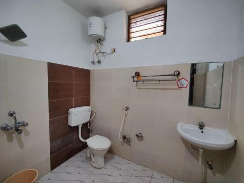 a bathroom with a toilet and a sink at Hotel Surya Greens in Puri