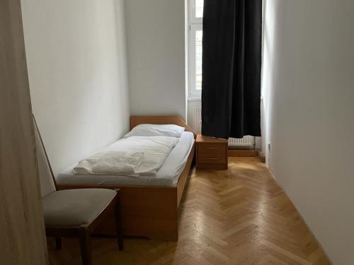 um pequeno quarto com uma cama e uma cadeira em easybook-in em Viena