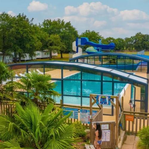 une piscine dans un parc aquatique avec deux toboggans dans l'établissement Camping Tohapi Coeur de Vendée, à La Boissière-de-Montaigu