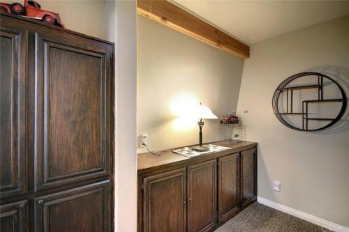 Habitación con armario de madera y espejo. en Cozy Mountain Retreat with Private Jacuzzi en Big Bear Lake