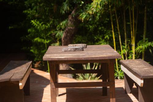a wooden picnic table with two benches next to it at CASA CHOCOLATE in Malcocinado