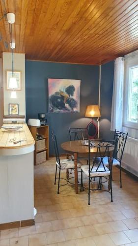 une salle à manger avec une table et des chaises dans une pièce dans l'établissement Maison sur un terrain boisé proche de Rocamadour., à Montvalent
