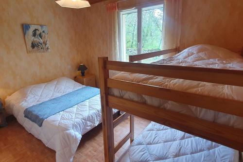 deux lits superposés dans une chambre avec fenêtre dans l'établissement Maison sur un terrain boisé proche de Rocamadour., à Montvalent